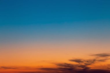 Cennetlik manzara. Güneş batarken ya da şafak vakti güzel turuncu ve mavi bulutlarla dramatik güneşli gökyüzü ile soyut doğal arkaplan