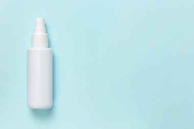 Plastik kap, kozmetik cilt antiseptik antiseptik dezenfektanı için beyaz şişe spreyi virüslerden el hijyeni, mavi arka planda bir salgın hastalık salgını ve fotokopi alanı.