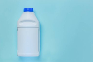 Plastik ambalaj, konteyner düzeni, ambalaj ürünü. Kozmetik, ilaç, hijyenik deterjan için beyaz, temiz, boş şişe. Mavi arka planda fotokopi alanı olan bir deterjan.