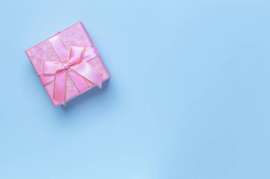 Kutlama afişi, satılık poster, hediye paketi, bayram için kurdeleli güzel pembe kutu pastel arka planda mavi renklerde, fotokopi odası manzaralı, düz benekli.