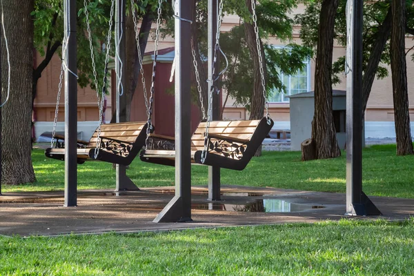 The swing is empty in the park in the summer in Saratov in the square named after Radishchev overlooking Teatralnaya Square, a recreation area in the city among green trees
