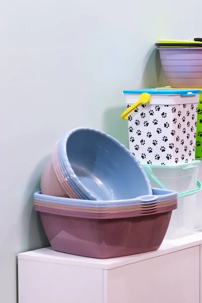 Home space organization, many different plastic household goods for storage and cleaning, selection of new clean washbowl, convenient containers with a lid on the shop window