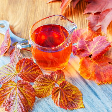 Sonbahar konsepti sıcak sabah çayı içmek ahududu yapraklarının ahşap arka planda bitkisel terapi için sağlıklı doğal karışımı.