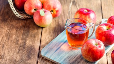 Kırmızı ve yeşil elma tarımının işlenmesi. Ev yapımı, sağlıklı diyet vejetaryen yemekleri. Elma sirkesi, meyve suyu, olgun meyvelerin yanında cam bir kavanozda elma şarabı.