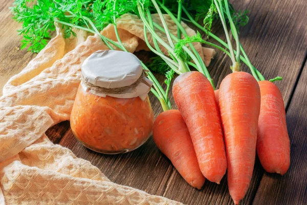 Canned carrot sauce salad with garlic and horseradish in a jar with fresh vegetables, recipe homemade diet vitamin preserves, chopped grated caviar dressing for soup on natural wooden table background — Stock Image Canned Carrot Sauce Salad Garlic Horseradish Jar Fresh Vegetables Recipe Stock Image