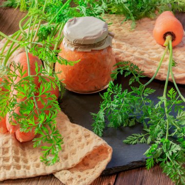 Kavanozda sarımsak ve yabanturpu ile konserve havuç salatası, taze sebzeler, ev yapımı diyet vitamin reçelleri, doğal ahşap masa arkasında çorba için rendelenmiş havyar sosu.