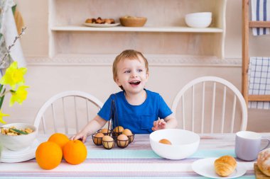 Mutfakta küçük bir çocuk. Mutfakta yumurta ile oynayan çocuk. Modern mutfak ışık. Mutlu çocukluk kavramı. Gülen ve having fun küçük çocuk.