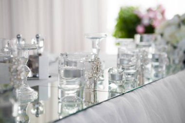 Tablo yeni evliler akşam yemeği için lüks restoranda, görünümü kapatın. Beyaz mum, çatal bıçak takımı ayna üzerinde.