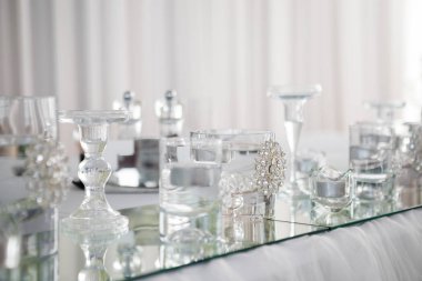 Tablo yeni evliler akşam yemeği için lüks restoranda, görünümü kapatın. Beyaz mum, çatal bıçak takımı ayna üzerinde.