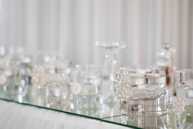 Tablo yeni evliler akşam yemeği için lüks restoranda, görünümü kapatın. Beyaz mum, çatal bıçak takımı ayna üzerinde.