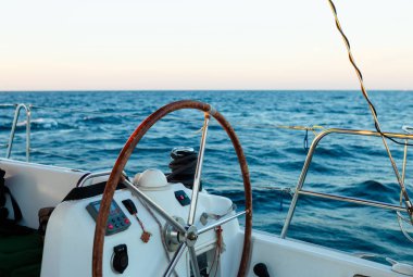 ?Tim tekerleğin arka plan üzerinde insanlar, mavi deniz susuz Yelkenli Yat. Yelkenli Yat denetim tekerlek ve navigasyon uygulanması.