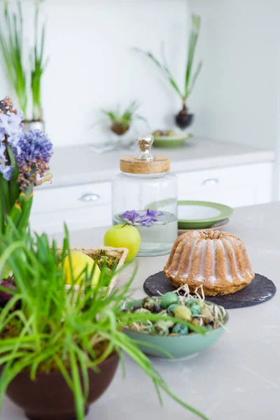 Modern Bright Kitchen Table Green Flowers Cake Perail Eggs White — стоковое фото