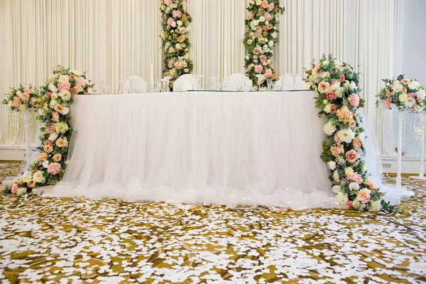 白いテーブル クロス クリスタル グラス カトラリー 床に白い紙吹雪の結婚披露宴のテーブル — ストック写真