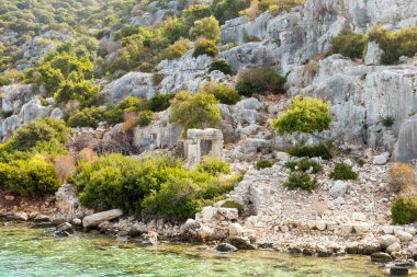 Kekova Adası, Türkiye antik kenti kalıntıları. Antalya İli Türkiye'nin turkuaz deniz kayalar ve yeşil çalılar denizden görüntülemek.