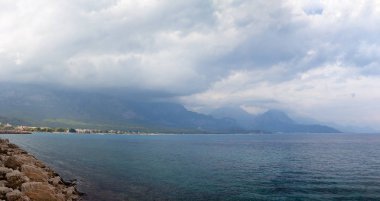 Kemer, Türkiye'nin kıyısında liman. Akdeniz bulutlu hava, arka planda dağlar.