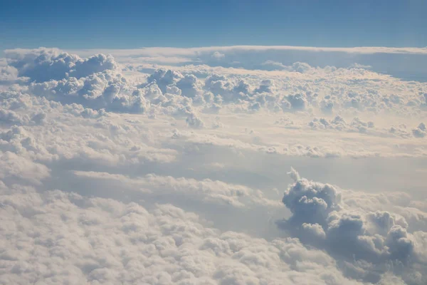 Above the sky, view from window of airplane flying in the clouds. Clouds, sky, airplane view.