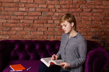 Düşünceli öğrenci kız kitaplar ile okuyor.