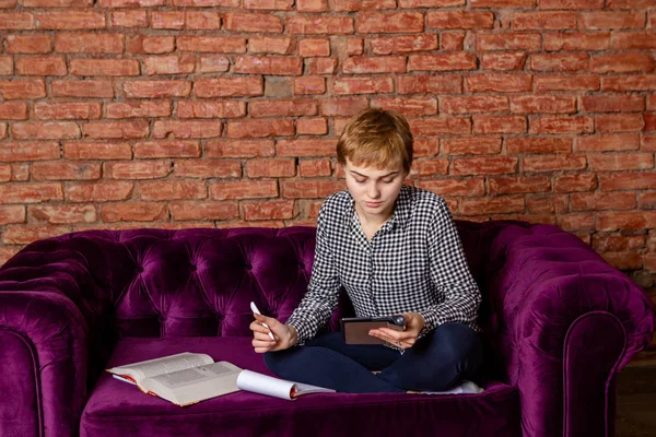 Female student with tablet sitting on sofa. — Stock Photo, Image