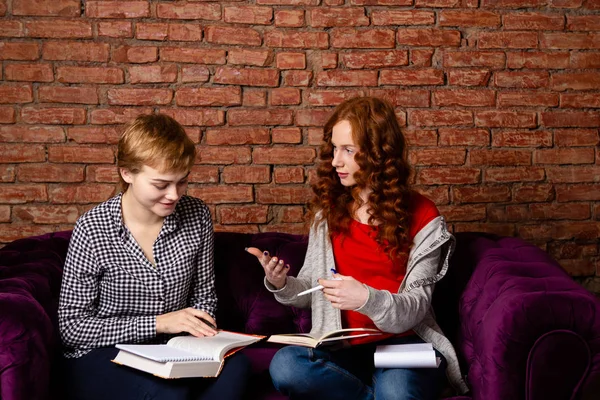 Två kvinnliga studenter skriver anteckningar. — Stockfoto