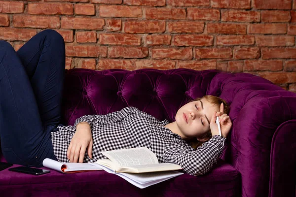 Oververmoeid student meisje slapen op sofa. — Stockfoto