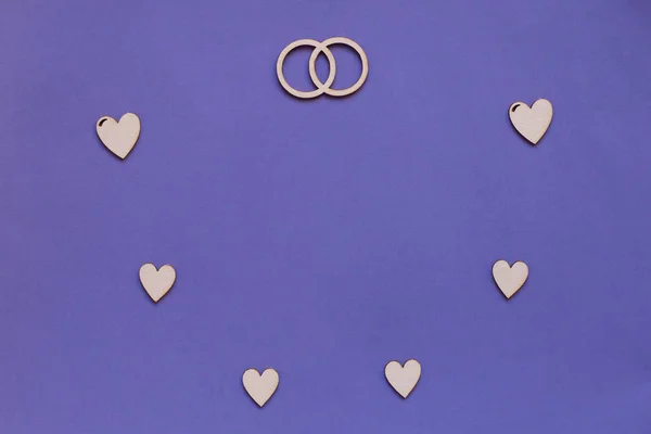 Wedding card design with wooden hearts and rings.