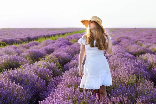 Mulher de vestido branco, chapéu de palha no campo de lavanda . — Fotografia de Stock