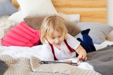 Evde tablet kullanan çocuk.