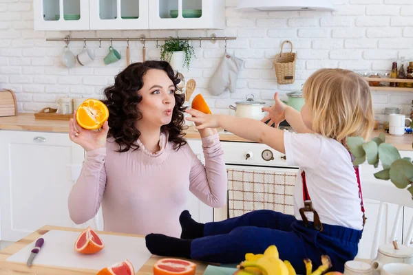 Mama i syn bawią się pomarańczami. — Zdjęcie stockowe