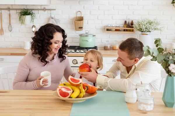 Father feeds son with fresh apple. — Stock Photo, Image