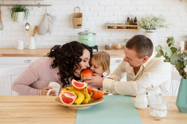 Mom and son bite an apple in the kitchen. — Stock Photo, Image