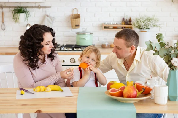 Parents feeding son with fresh fruits. — Stock Photo, Image