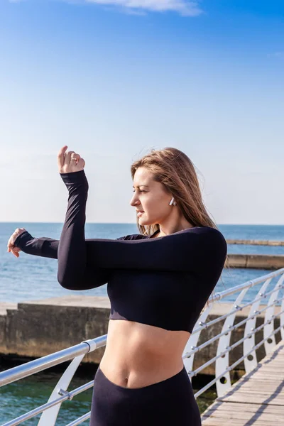 Sportliches Mädchen macht Aufwärmübungen am Meer — Stockfoto