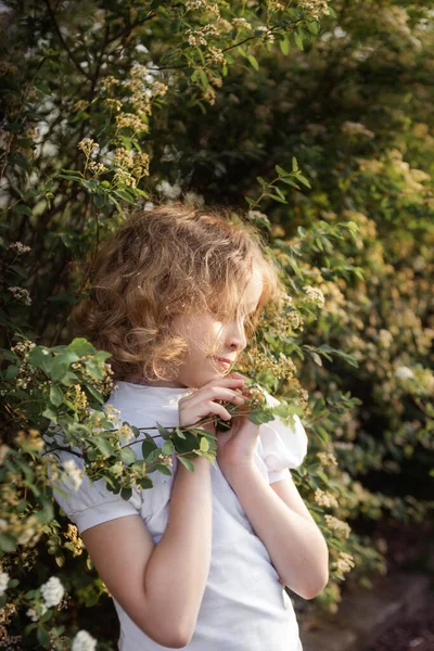 Çiçekli Küçük Bir Kız Çiçek Açan Çalıların Yanında Portre Yakın — Stok fotoğraf