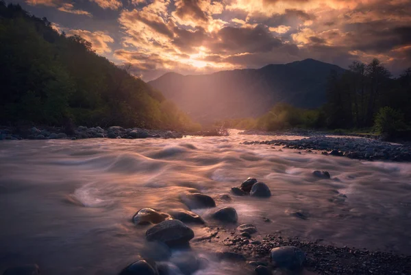 Hermoso atardecer sobre un río de montaña rápido — Foto de Stock