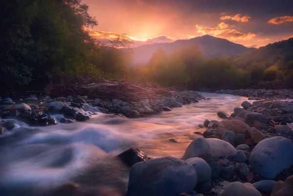 Beautiful sunset over fast flowing mountain river — Stock Photo, Image