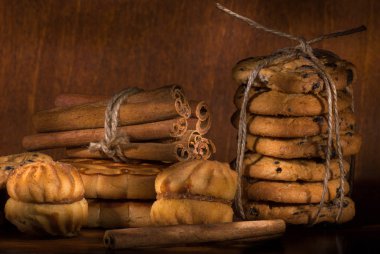 Ahşap bir arka planda çeşitli kurabiye ve tarçın içeren kavramsal kompozisyon, seçici odak, yakın plan