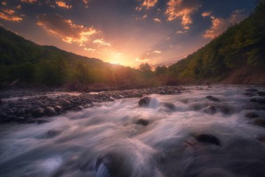 Hızlı akan dağ nehrinin üzerinde güzel bir gün batımı. Kafkas Dağları. Racha.