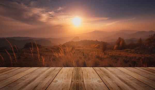 Colorful autumn sunset with sun rays coloring the hills. empty wooden table in nature outdoor
