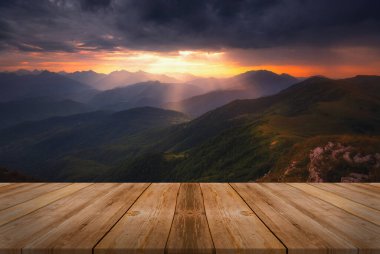 Yazın güzel arka planı, dağların üzerinde gün doğumu ve doğada boş ahşap masa. Doğal şablon manzarası.