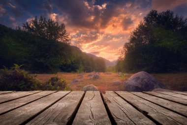 Yazın güzel arka planı, dağların üzerinde gün doğumu ve doğada boş ahşap masa. Doğal şablon manzarası.