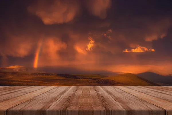 The Sky With beauriful Clouds And A Rainbow After The Rain with empty wooden table. Natural template landscape.