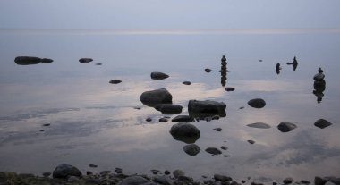 Coast su gökyüzü yansıması ile taş piramitleri