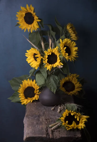 bouquet of sunflowers in vase on blue background