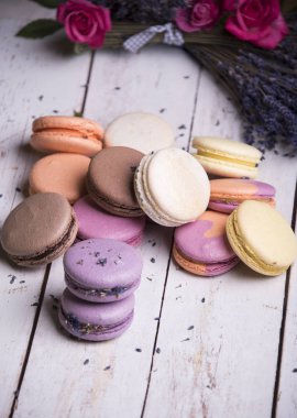 gül ve lavanta çiçekleri ahşap arka plan üzerinde renkli macaroons