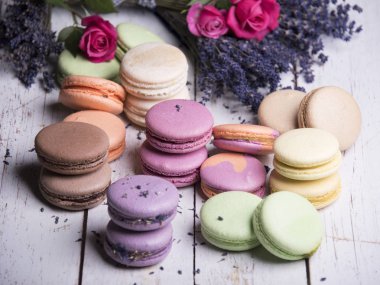 gül ve lavanta çiçekleri ahşap arka plan üzerinde renkli macaroons