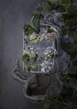 taze çiçekler ve eşarp ile rustik metal sepet üstten görünüm