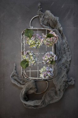 taze çiçekler ve eşarp ile rustik metal sepet üstten görünüm