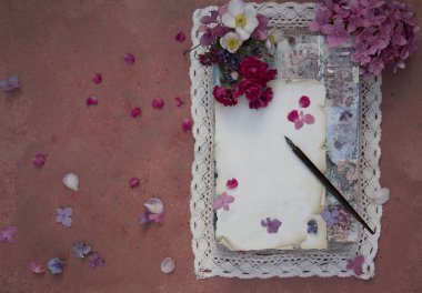 Kopya alanı peçete, DIP kalem ve masaya çiçek ile eski kağıt levha.