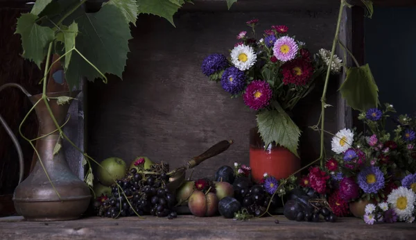 Νεκρή Φύση Φρούτα Μεταλλική Κανάτα Και Βάζο Λουλούδια Στο Τραπέζι — Φωτογραφία Αρχείου