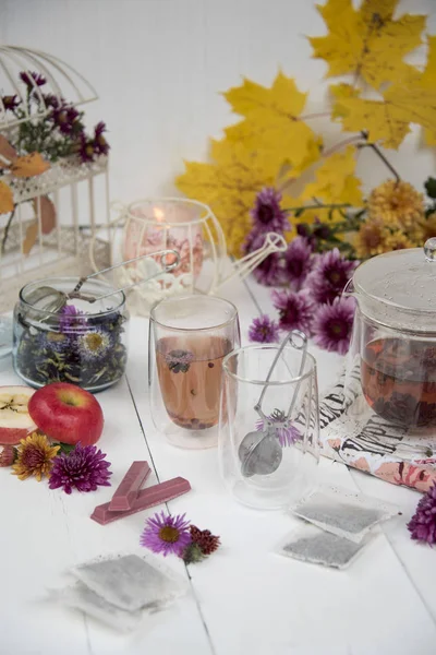 Komposition Aus Glas Teekanne Tassen Mit Kräutertee Blumen Äpfeln Und — Stockfoto